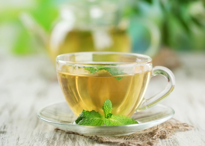 Травяной чай с листочком мяты на блюдце